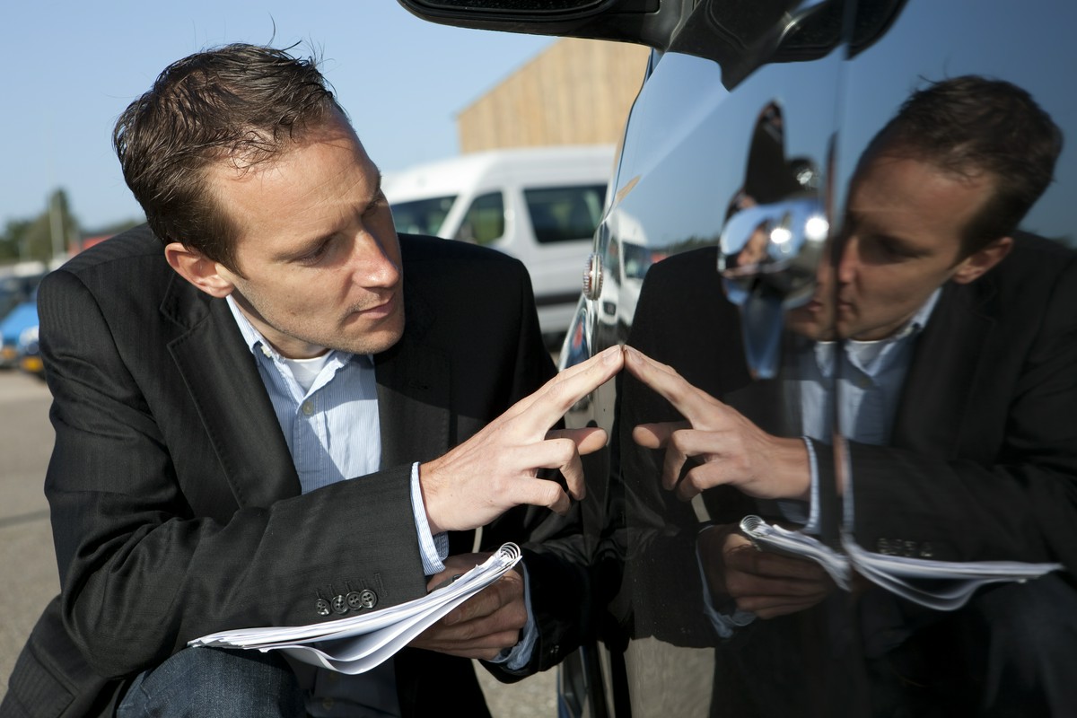 agent ubezpieczeniowy sprawdza samochód